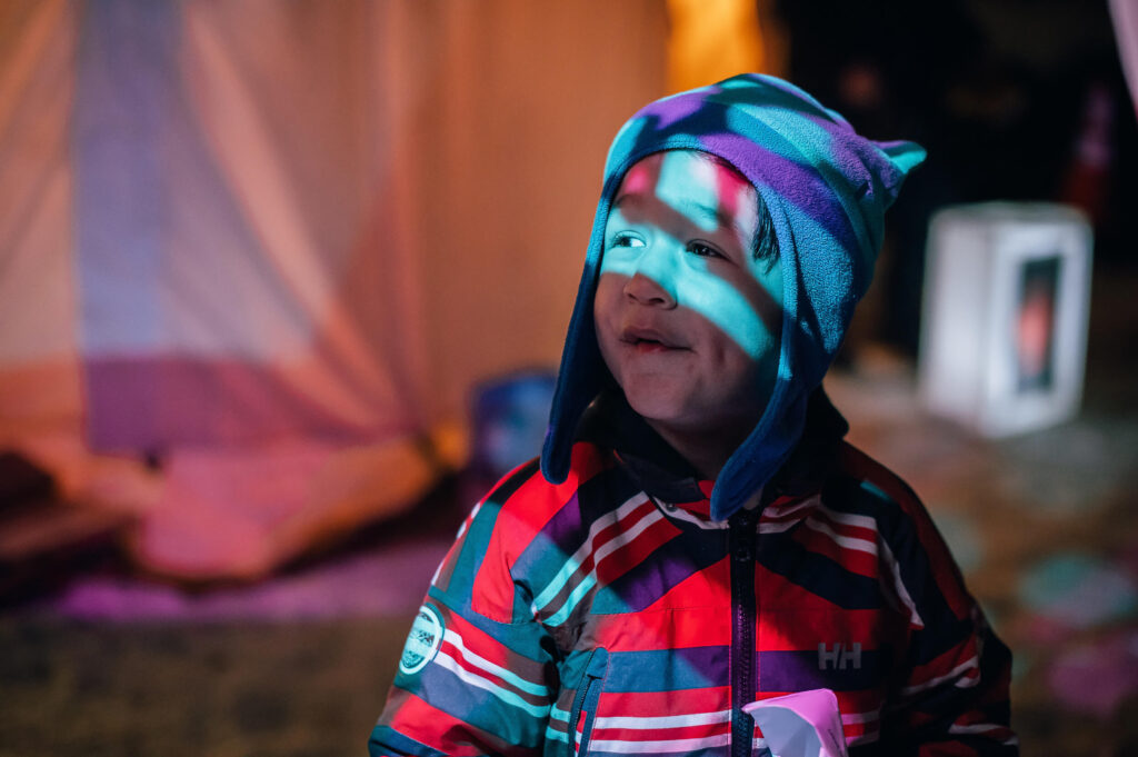 A preschooler looking at lights at the Flying Canoe Volant Winter Festival in Edmonton