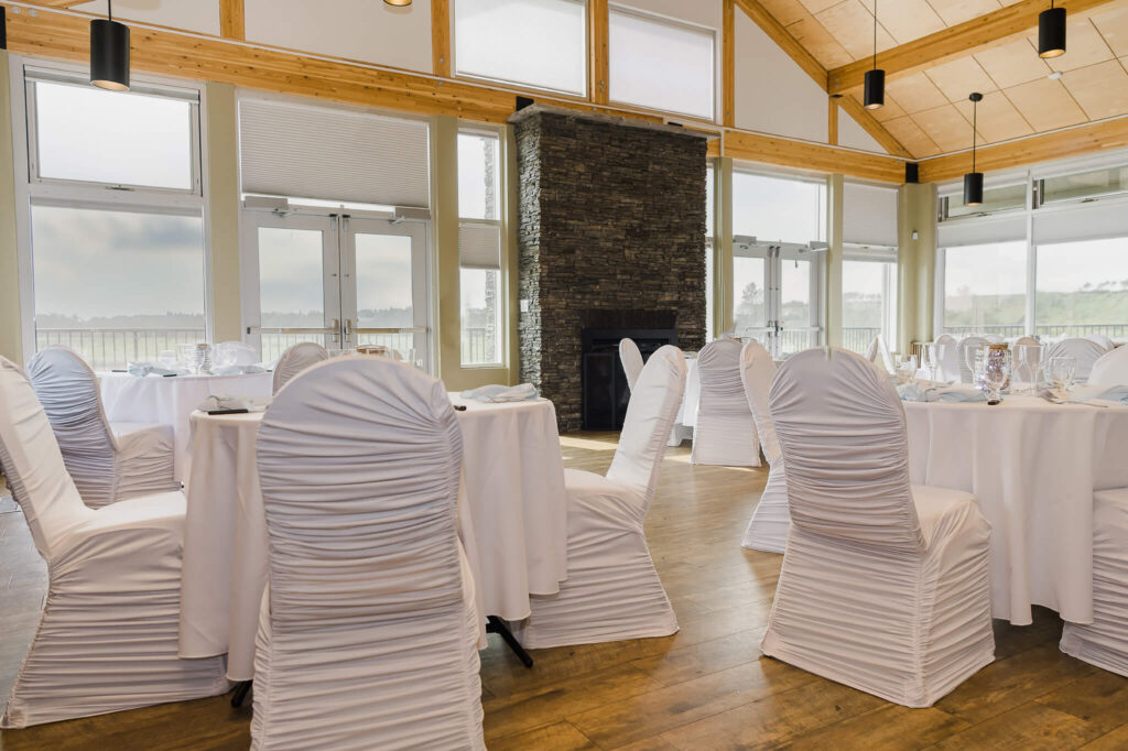 Decor of tables and chairs dressed in white by Sevy from Pop Up Weddings YEG at West River's Edge in Fort Saskatchewan, Alberta