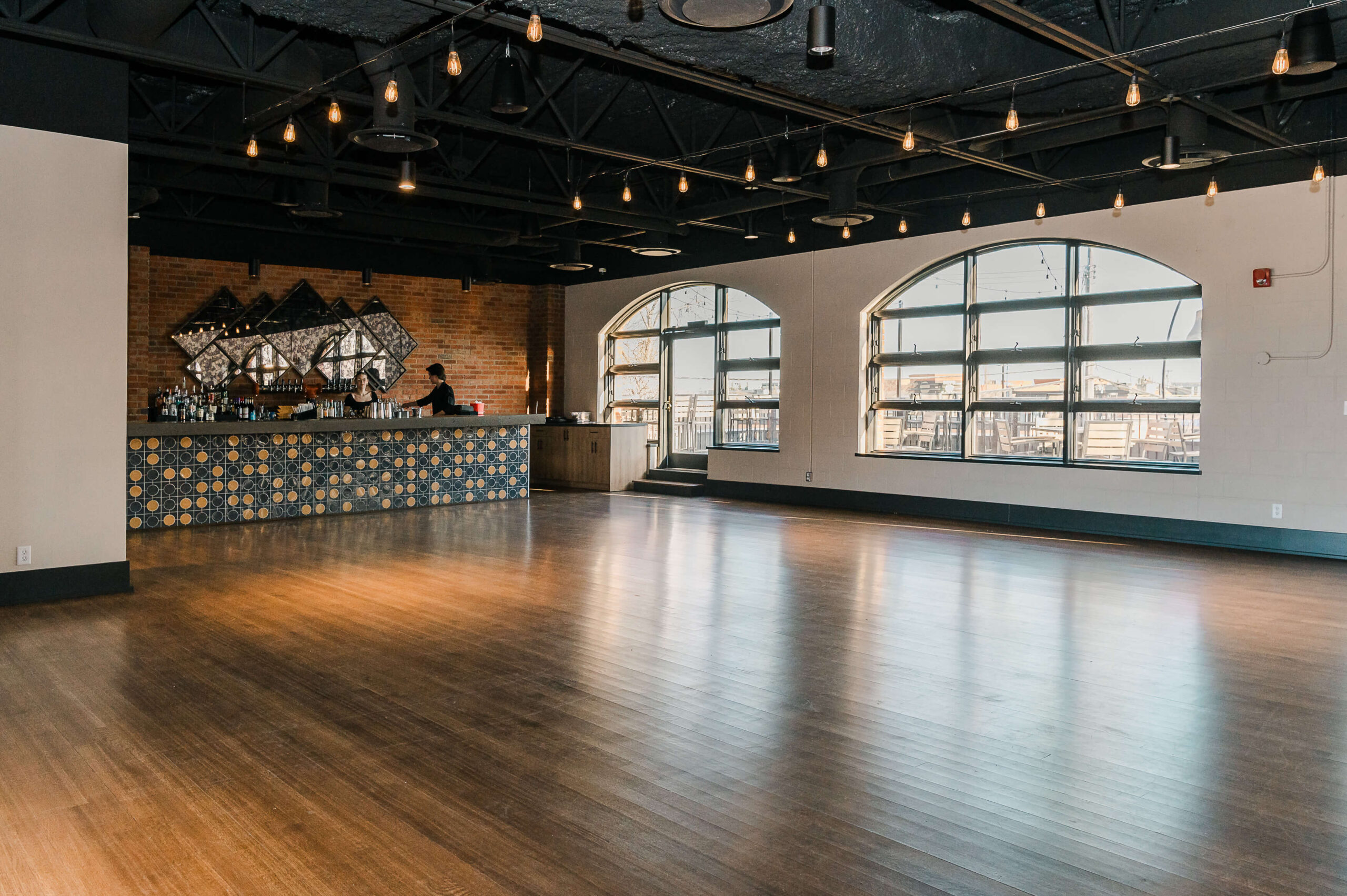 The Bell in Scona Wedding Venue with large windows for natural light and a fully stocked service bar. It has a hardwood floor and is fully sound-proofed