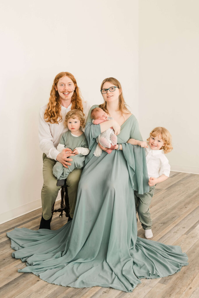 An Edmonton family with a newborn dressed in mint green and white neutrals