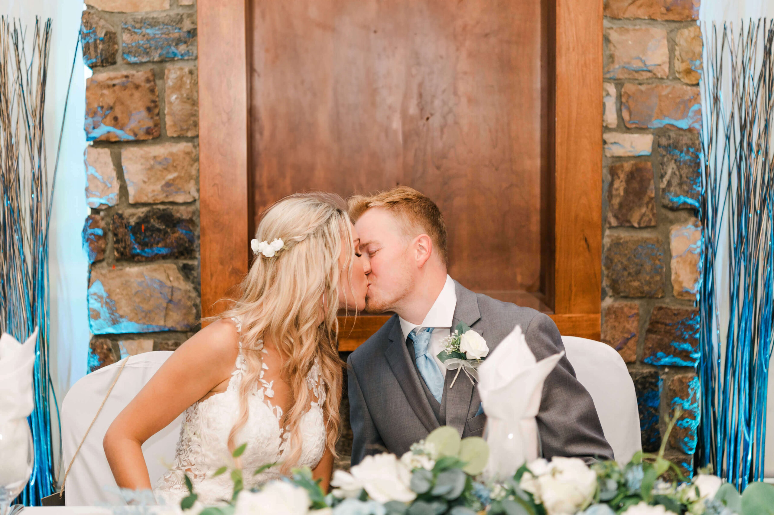 a man and woman kissing in front of a stone wall at an Edmonton Derrick Club Wedding