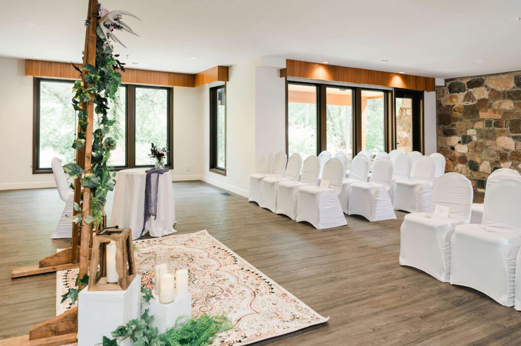 a room with white chairs and tables with a decorated triangular arch with candles at the inside of Yorath House