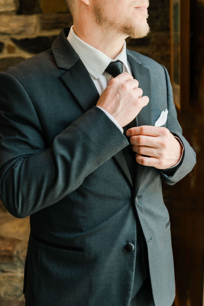 a man in a suit adjusting his tie