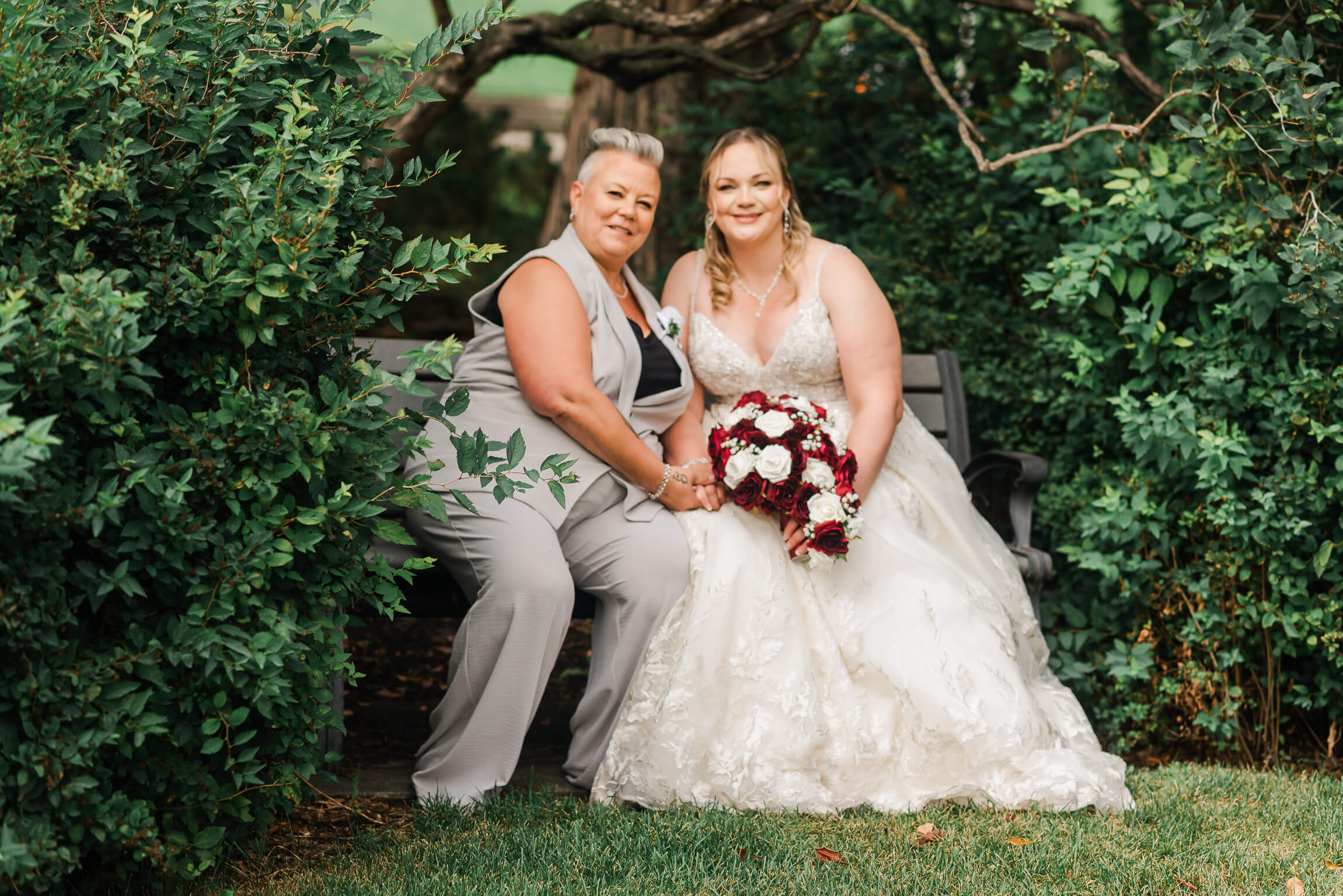 A woman and woman sitting on a bench in the middle of their Westin Edmonton Wedding