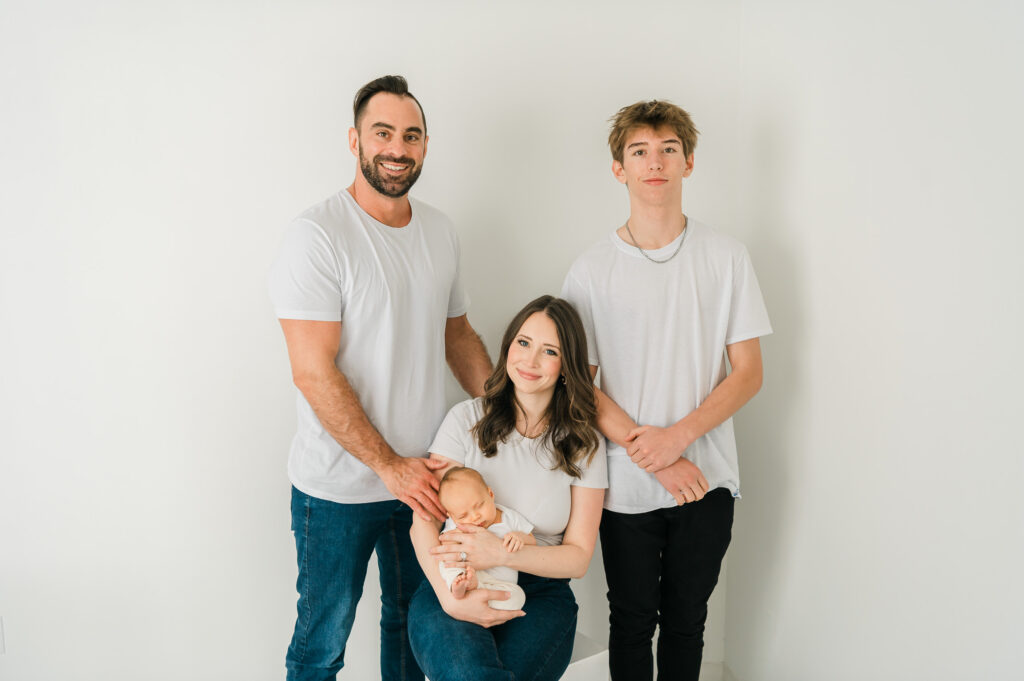 A Family of four with a mom holding a baby