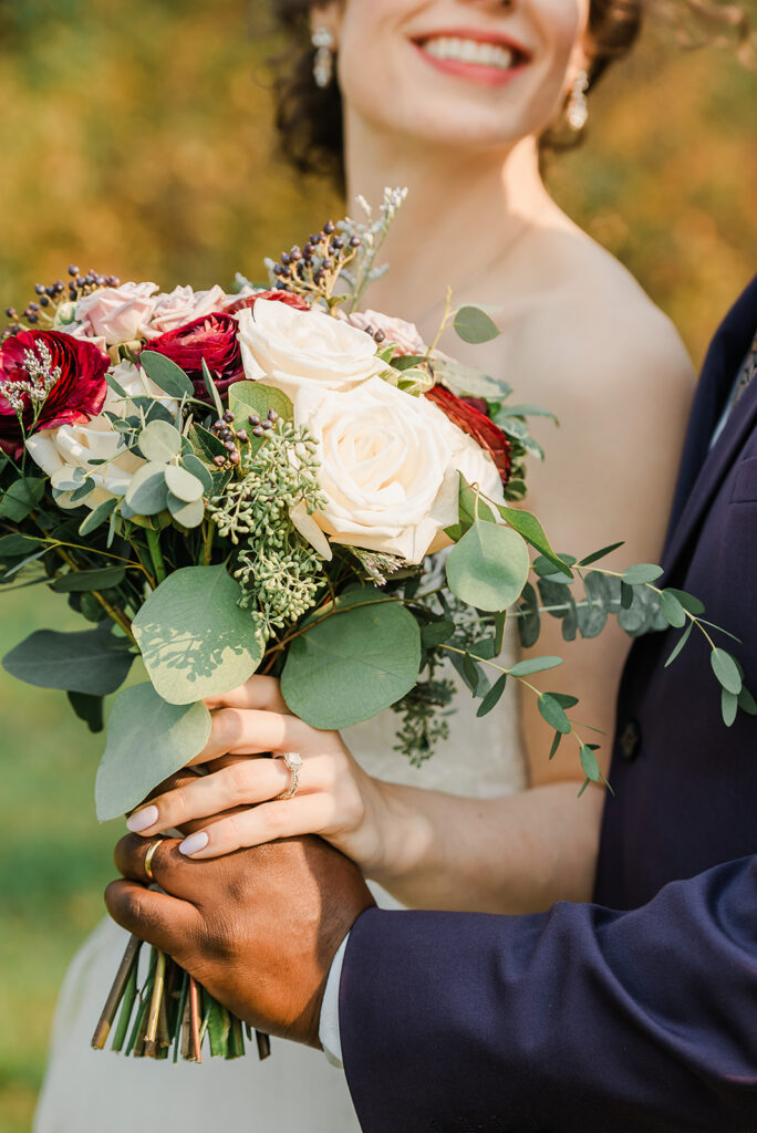 A romantic moment of a couple holding hands together while showing off wedding rings