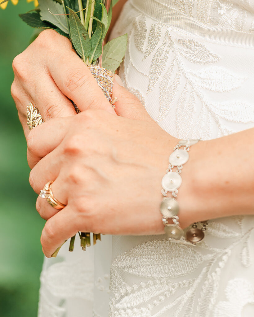 Close up of Verragio engagement ring while bride is holding her bouquet