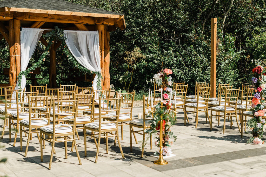Outdoor gazebo ceremony with gold chiavari chairs and welcome sign at the Cornerstone Venue in Edmonton