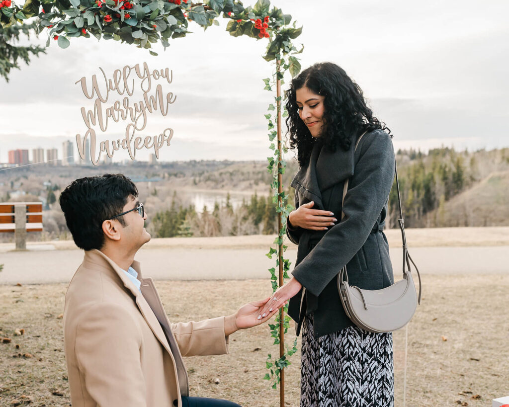 Candid moment of a groom proposing to his future bride during early spring in Edmonton, Alberta