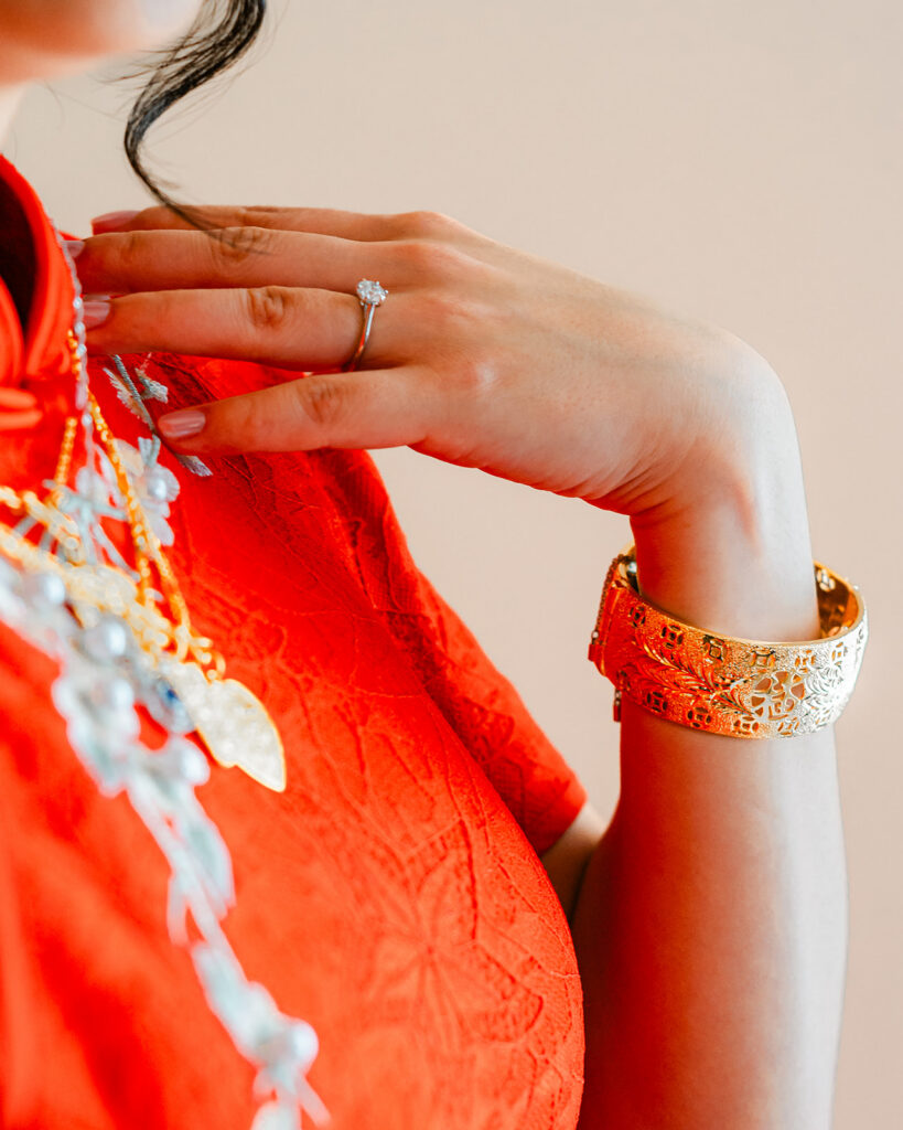 Editorial close up detail of an Edmonton engagement ring being worn with Chinese cultural jewelry right after a tea ceremony