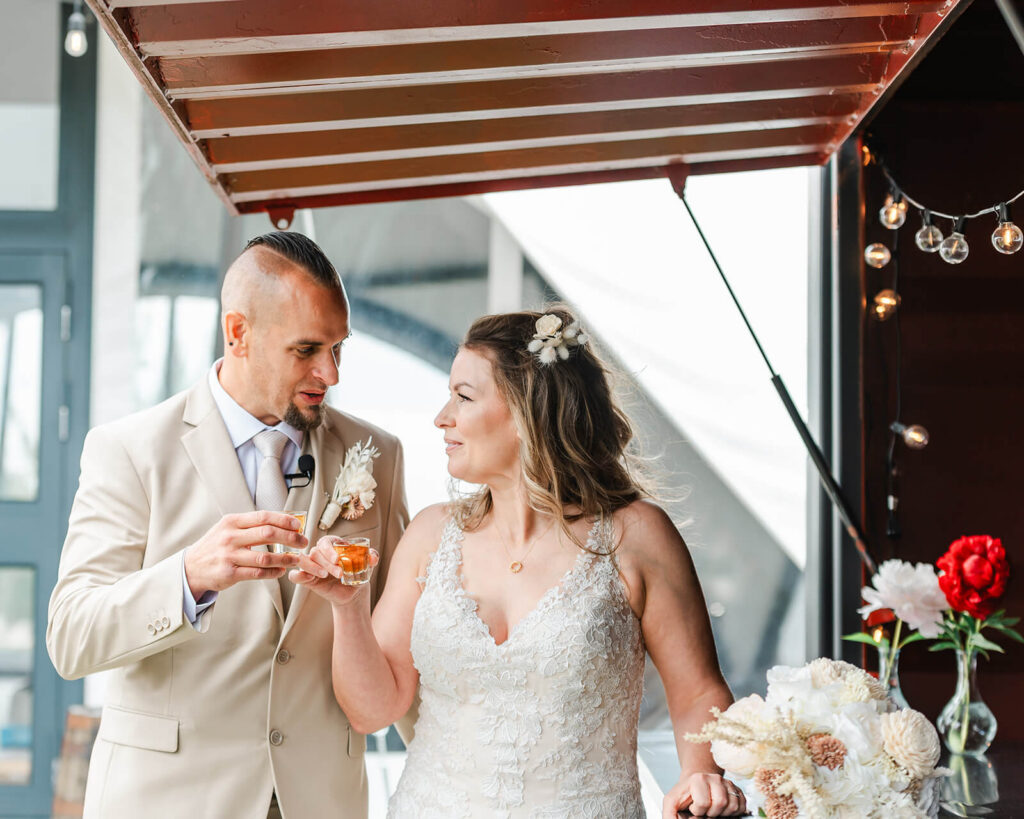 Bride and groom sharing a drink at the Seacan bar during cocktail hour