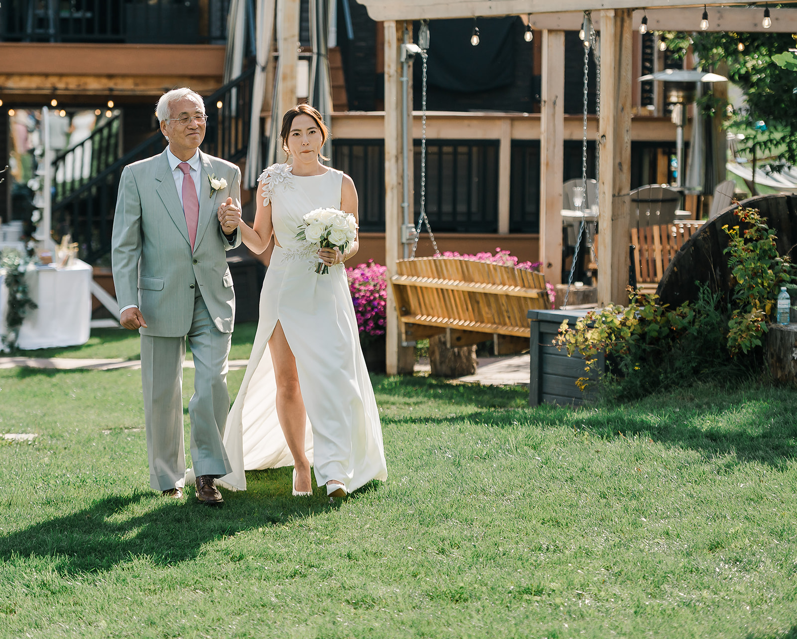 Bride walking down the aisle on her father’s arm at a Dragonfly Inn Sherwood Park wedding ceremony