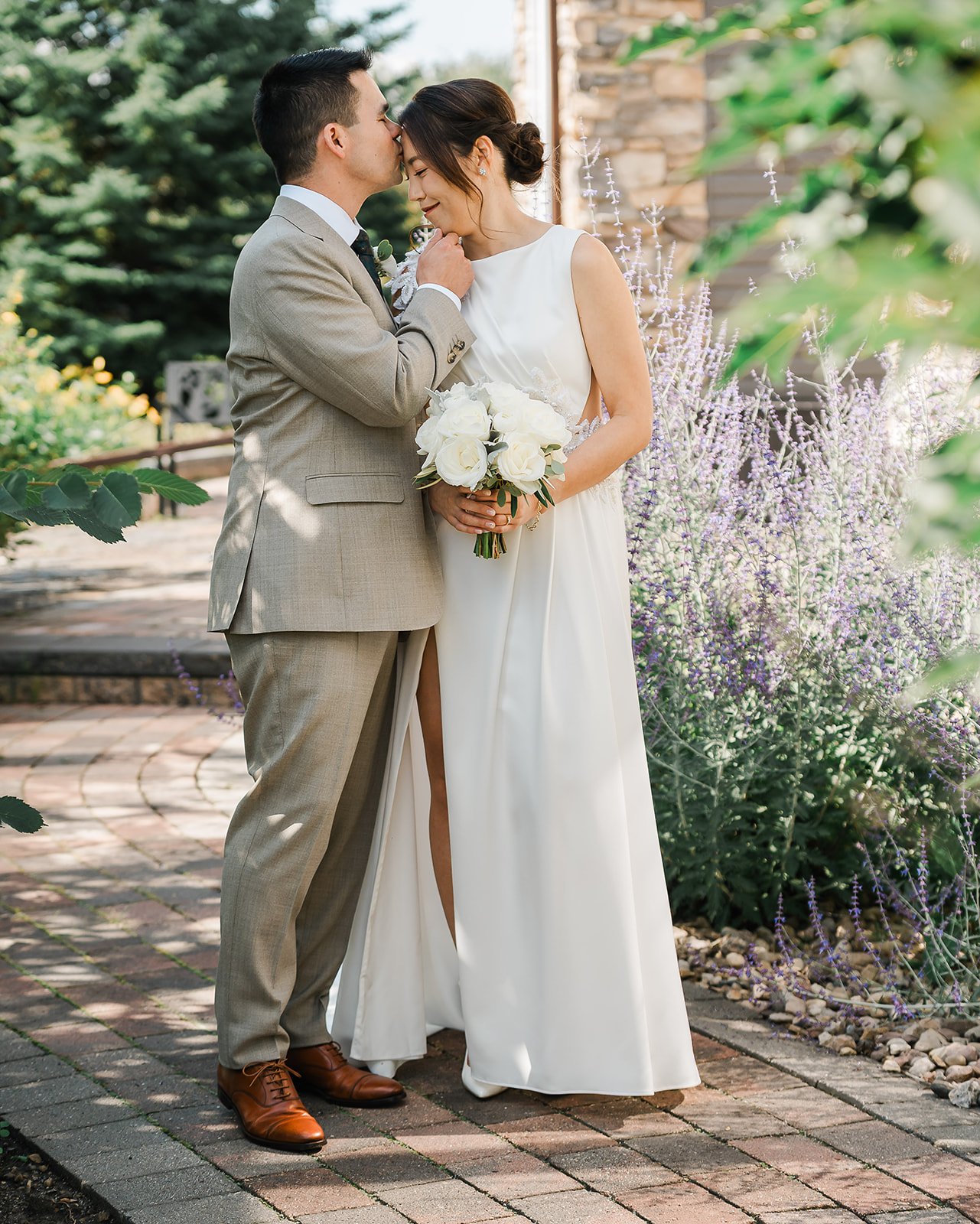 Bride and groom share a forehead kiss among lavender at a Dragonfly Inn Sherwood Park wedding